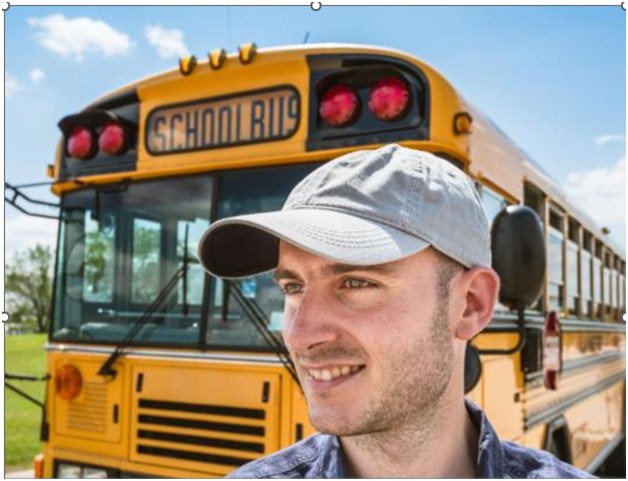 A person in front of a school busDescription automatically generated